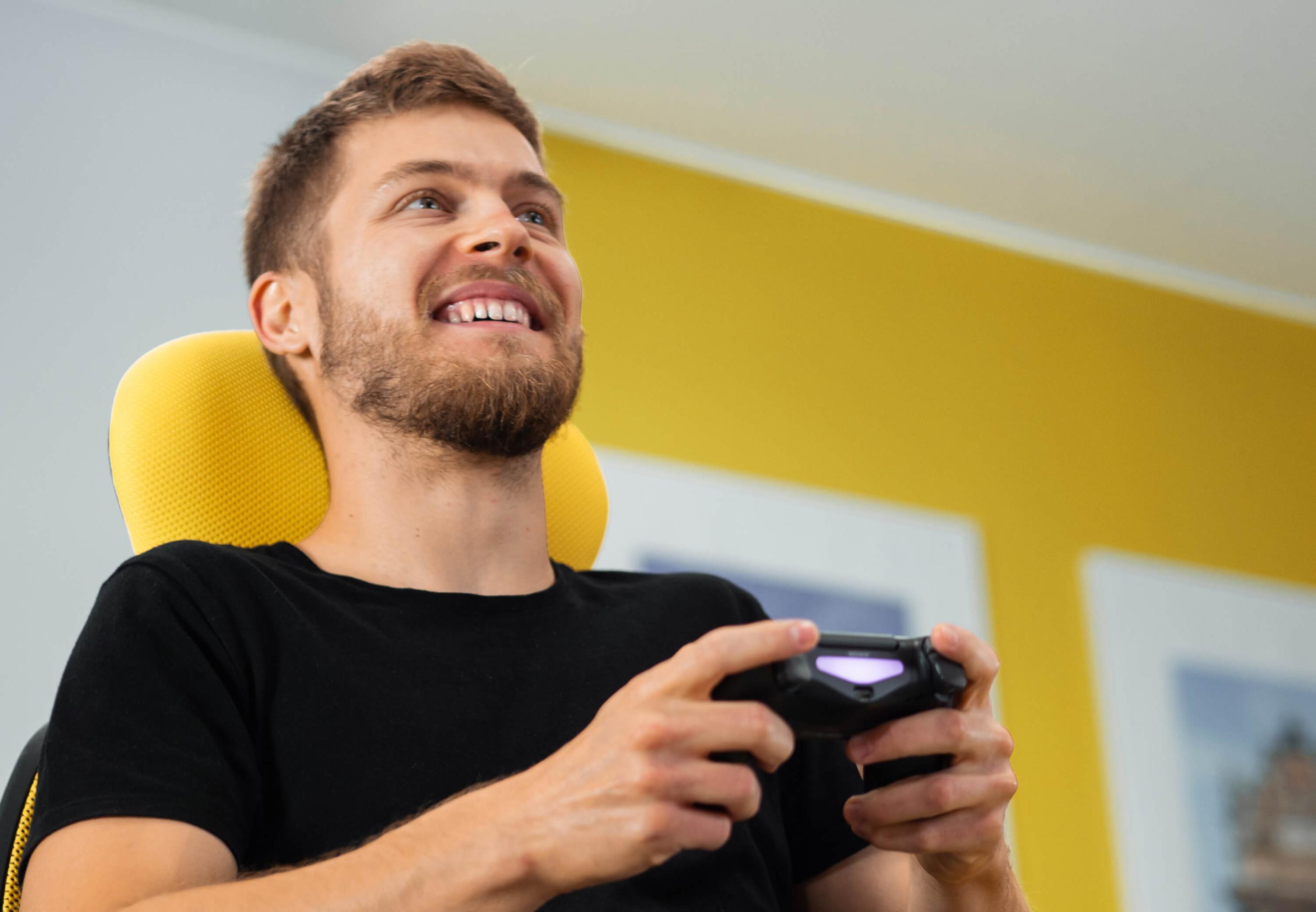 A photo of a man holding a Playstation gamepad